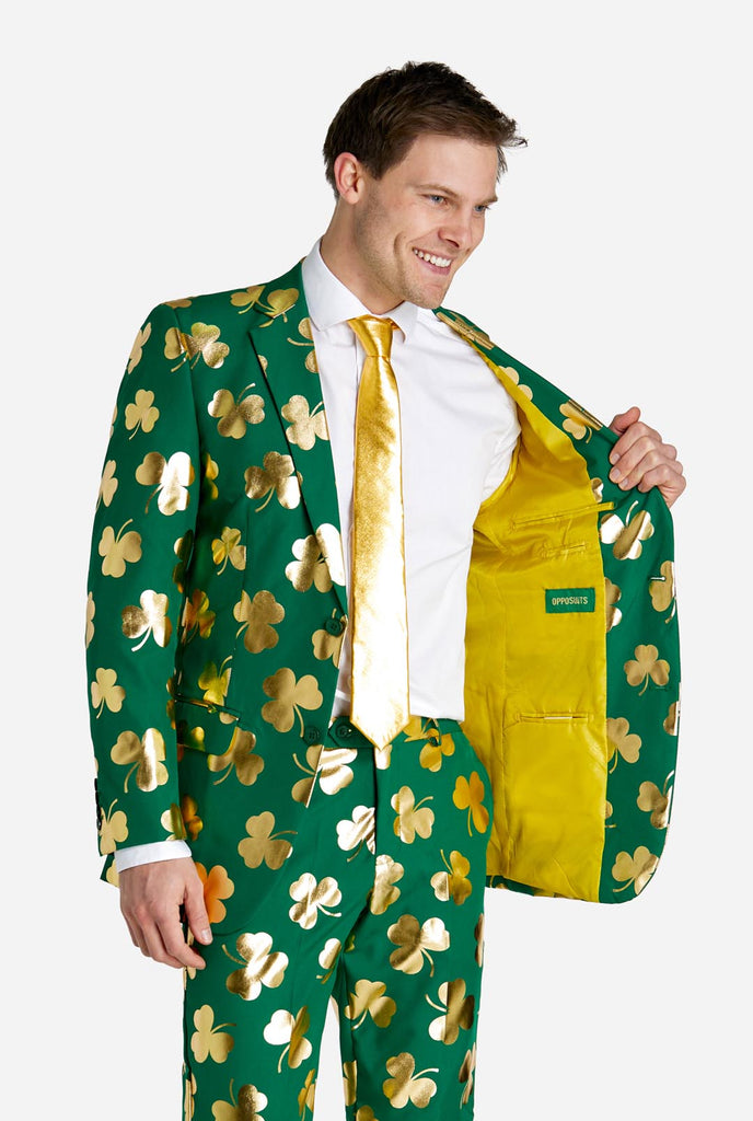 Man wearing green St Patrick's Day suit with golden clovers.