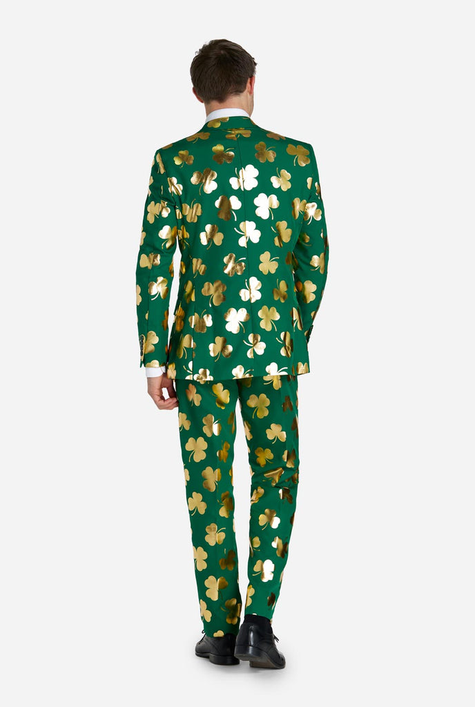 Man wearing green St Patrick's Day suit with golden clovers, view from the back.